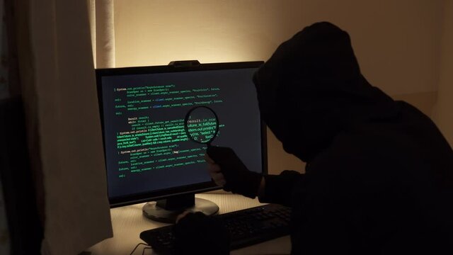 Hacker looking for a flaw in the program code.