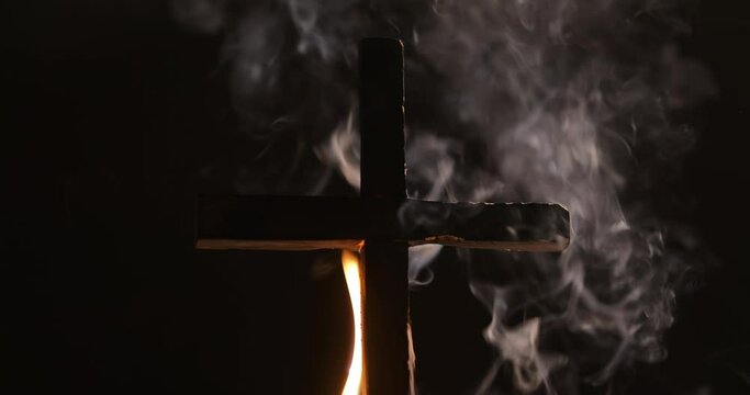 Burning cross with smok in dark night