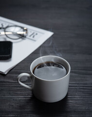 Cup of coffee with newspaper on a wooden table