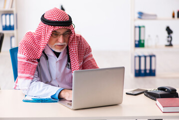 Old male arab doctor working in the clinic