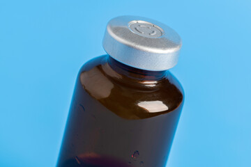 Macro Image Of Amber Vaccine Vial In Blue Background
