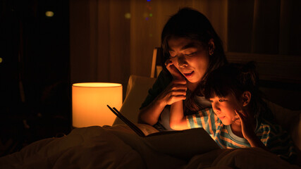 mom and daughter have goodtime reading bedtime stories for daughter