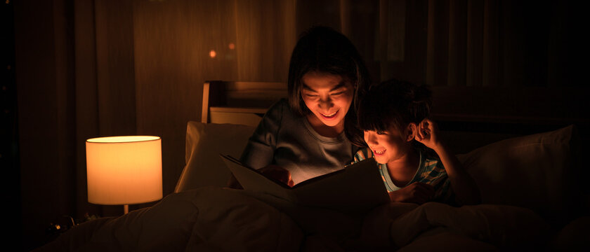 mom and daughter have goodtime reading bedtime stories for daughter