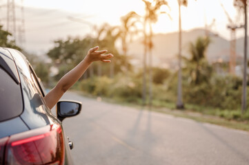 A girls happy traveling enjoy holidays and relaxation   the atmosphere and go to destination.Car travel driving road trip of woman summer vacation at sunset.Holiday,travel and vacation