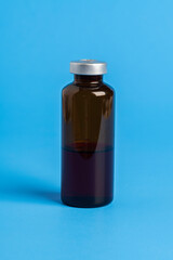 Macro Image Of Amber Vaccine Vial In Blue Background