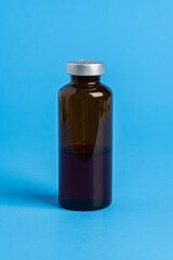 Macro Image Of Amber Vaccine Vial In Blue Background