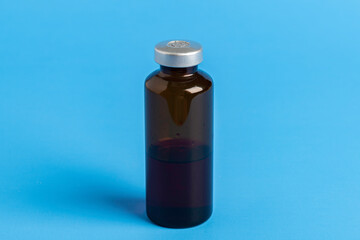 Macro Image Of Amber Vaccine Vial In Blue Background