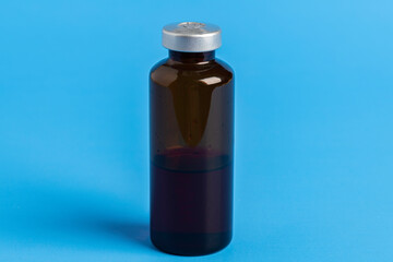 Macro Image Of Amber Vaccine Vial In Blue Background