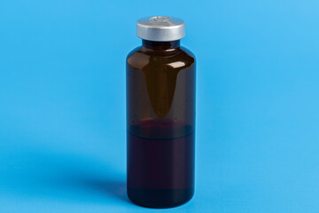 Macro Image Of Amber Vaccine Vial In Blue Background