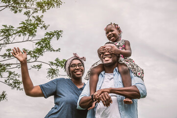 Fototapeta premium Happy African families in the garden with a daughter riding their father's neck.