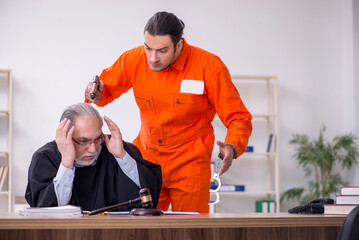 Old male judge meeting with young captive in courthouse
