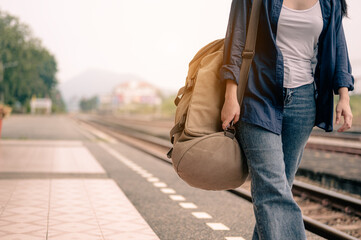 Young asian woman walking and waits train on railway platform..Concept of tourism, travel and recreation.