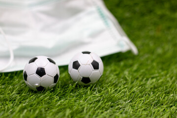 soccer ball with face masks background on green grass