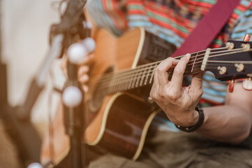 A man playing guitar on stage at a music festival..Concert,mini concert and music festivals.