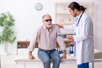 Old blind man visiting young male doctor