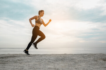 Fototapeta premium Asian women jogging in the sand on the beach in the morning.Exercise,Fitness ,workout, gym exercise ,lifestyle and healthy concept.