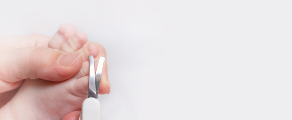 Banner.Baby manicure. Mother cutting kids nails with child-safe scissors. Close up. Copy space. 