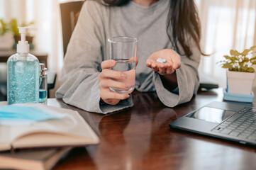 Pill in her hand. young woman holding a glass with water and pills in her hands..coronavirus.covid-19 outbreak pandemic.