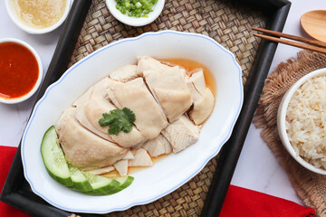 Hainanese Chicken rice - famous Singapore food top view served on the bamboo tray 