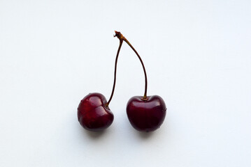 Two cherries on a white background close up