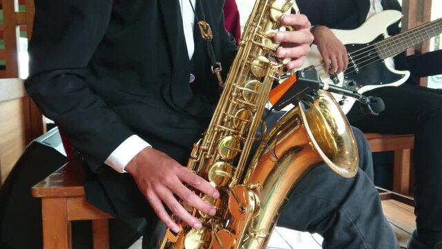 Cool saxophone player performing on stage. Musician playing in jazz band