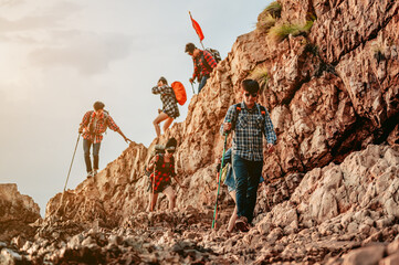 A group of hikers descend from the top of the mountain, traversing the mountainside through the...