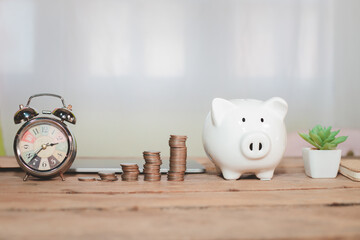White piggy bank with coins placed in a row, concept of saving money for the future;