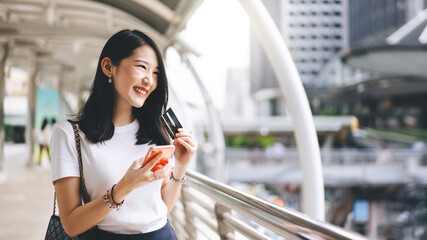 Young adult business asian woman consumer using creadit card and smartphone for shopping online.