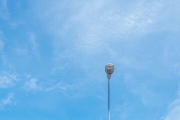 The street light pole stand against the bright blue sky background with copy space