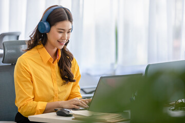 Happy young asian business woman wears headset talk to online video conference call with her...