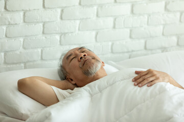 Fototapeta na wymiar Asian Elderly man close eyes smile sleep and sweet dream on bed in bedroom in the morning feeling so relax and comfortable,Healthcare and Sleep Concept