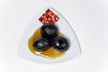 Fruity sweetness of jam on a saucer and a white background. The view from the top