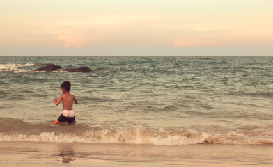 Fototapeta na wymiar A boy playing in the sea having fun alone