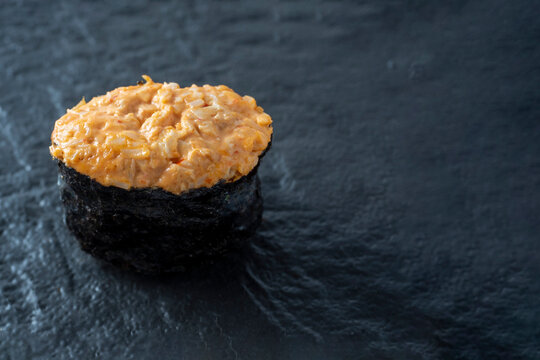 spicy guncan with chicken and spicy sauce on a dark textured surface. Side view, copy space