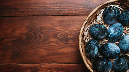 blue Easter eggs in a basket on a wooden background