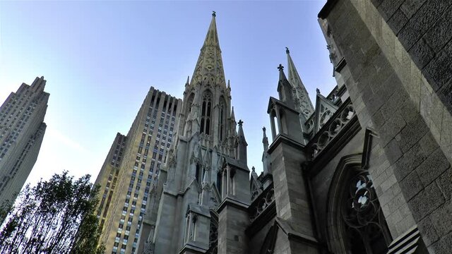 Low angle view of St Patrick Cathedral standing among other buildings in Manhattan, New York.