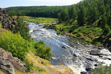 Gray large boulders lie in a mountain river