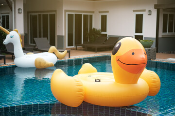 Closeup inflatable yellow rubber duck on swimming pool, Holiday on summer fun party in pool villa...