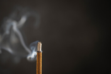Asian incense stick burning with smoke, close up, macro