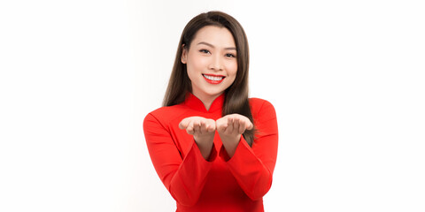 Young attractive woman advertising something holding on her palm in a red ao dai front face