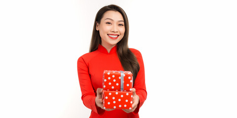 Cheerful young lady holding gift boxes in hands and looking at camera with toothy smiles while preparing for Lunar New Year celebration, isolated on white background