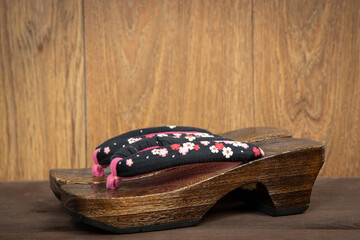 Japanese traditional geta sandal on wooden background. Traditional Japanese asian wood footwear...