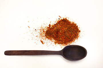 Dry saffron next to a wooden spoon. Spices for dishes. White background.