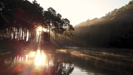 Amazing Morning sunlight at Pang Ung lake with Rowing boat and fog floating above the water surface, Pang Ung travel destination at Mae Hong Son province Thailand. Slide slowly left to right by drone. - Powered by Adobe