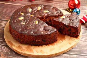 Homemade delicious sliced plum cake on a Christmas decorations background.