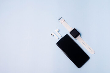 The layout of the watch and the phone on a blue background. Appliances and electronics. Modern...