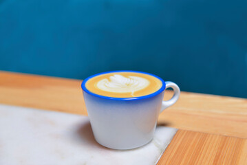 Coffee cup with coffee foam on wooden table. Latte coffee in restaurant or cafe, eating out concept, coffee concept.