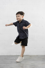 Studio shot portrait of happy little Asian boy on background