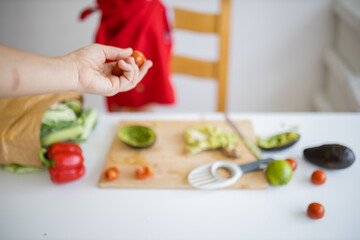 Female hand giving small tomatoes to a little girl at a table