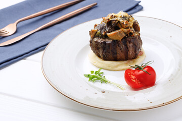 Veal medallion with mushrooms and tomato close up